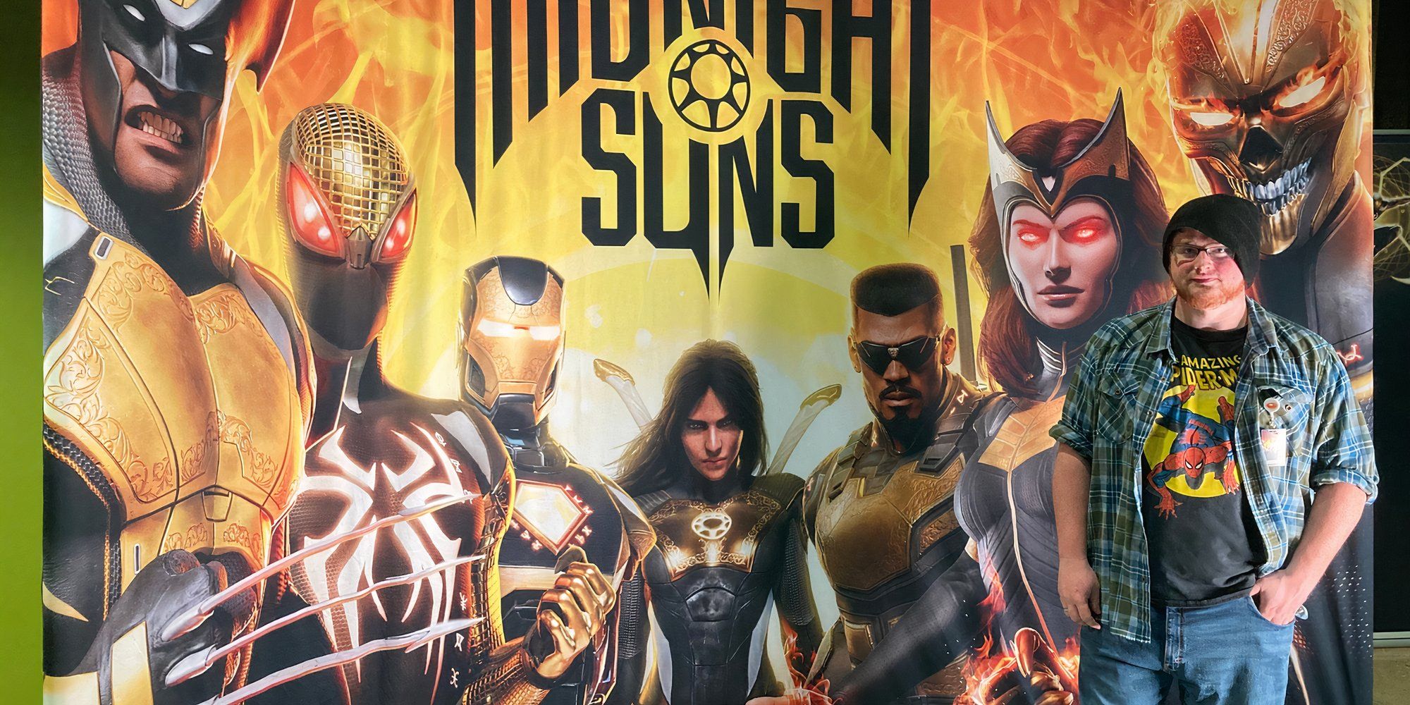 Joshua Duckworth standing next to large game poster of Marvel's Midnight Suns